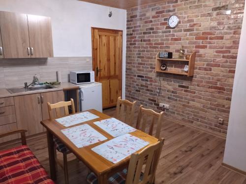 una cucina con tavolo, sedie e muro di mattoni di Apartmán 61 a Bajerovce
