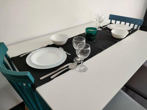 une table avec des assiettes et des verres sur un tissu de table noir dans l'établissement Studio Bleu, à Obernai