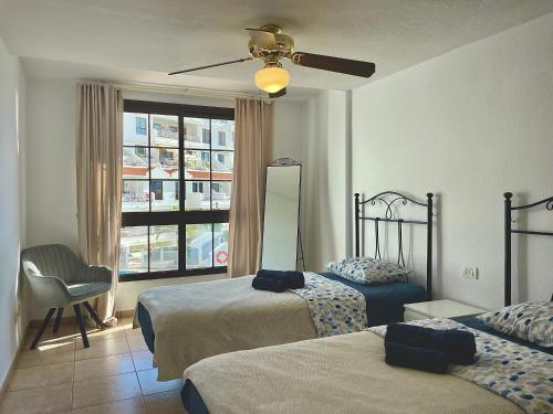 una camera d'albergo con due letti e una finestra di CASA VARGAS-TENERIFE a Los Cristianos