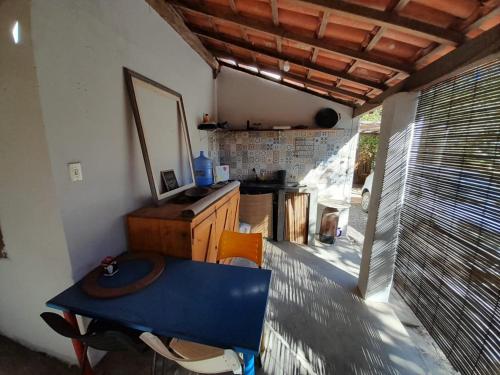 uma pequena cozinha com uma mesa azul num quarto em Suites na Vila em Maraú
