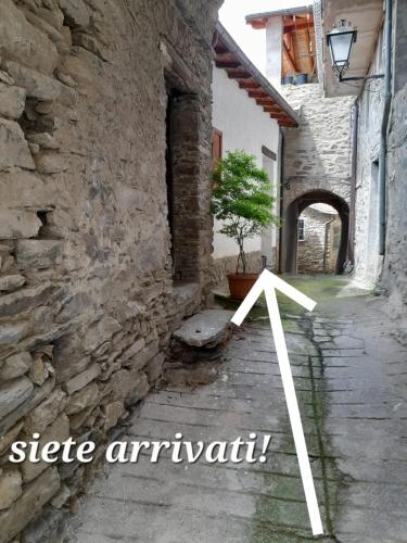 an arrow pointing to a building with a tree in an alley at Casa Vacanze La Mezzaluna in Molini di Triora
