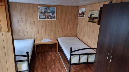 um pequeno quarto com duas camas e uma mesa em Baza Turystyczna Atol em Władysławowo