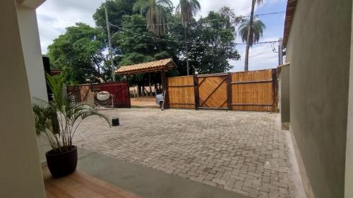 a patio with a wooden fence and a gate at Pousada Flor do Campo Cipó in Santana do Riacho