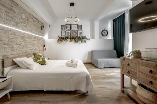 ein Schlafzimmer mit einem großen weißen Bett und einem Sofa in der Unterkunft Apartamentos Pino in Benidorm