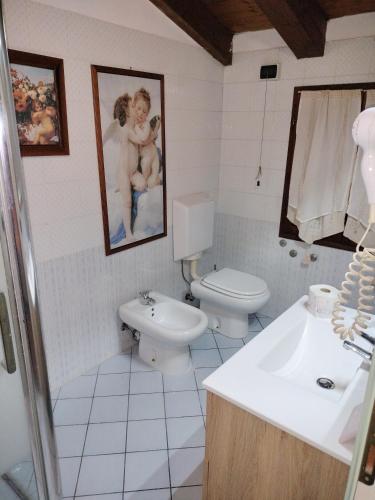 a bathroom with a toilet and a sink at La Divina in SantʼAgata Bolognese