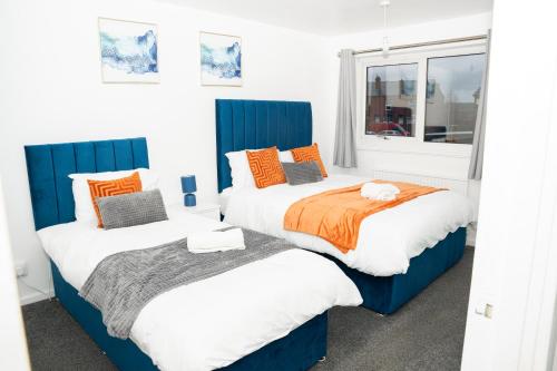 1 dormitorio con 2 camas y ventana en Stylish 3 bed house with free parking en Belle Isle