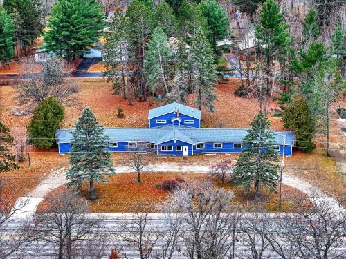 una vista aérea de una casa azul en el bosque en The Blue Anchor Unit #1, en Houghton Lake