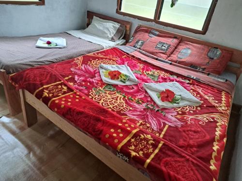 a bed with a red and gold bedspread and pillows at Appartement de Charles in Loméméti