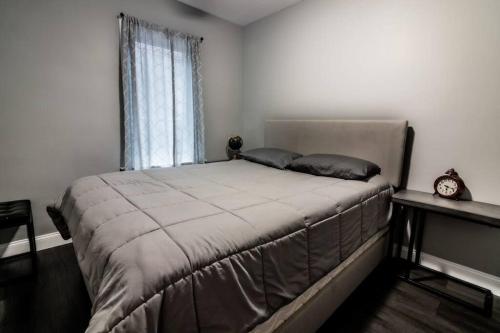 Schlafzimmer mit einem großen Bett und einem Fenster in der Unterkunft Comfortable 3BR, 1 Bath close to the falls in Niagara Falls