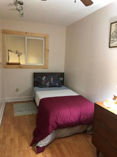 a bedroom with a bed with a purple blanket at Cliff’s Place in Iron Bridge
