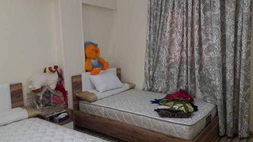 un pequeño dormitorio con una cama con un osito de peluche. en شقه مفروش في التجمع الخامس, en El Cairo
