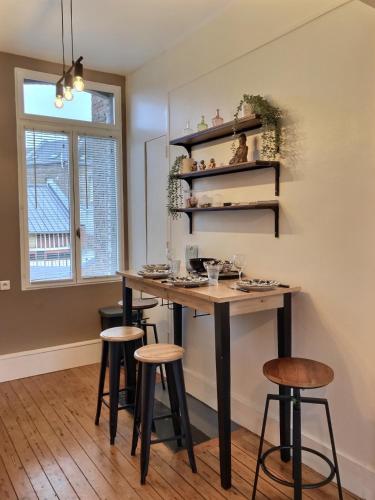 une cuisine avec une table et des tabourets dans une pièce dans l'établissement Beau Duplex proche Centre Gare, à Amiens