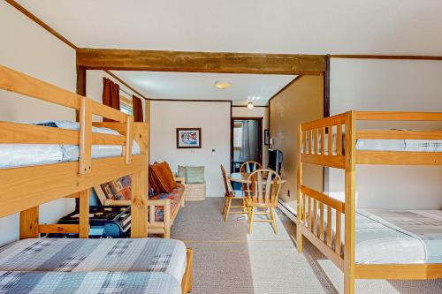 a room with two bunk beds and a dining room at Alpine Horn Lodge at Big Powderhorn Mountain - Unit B in Ironwood