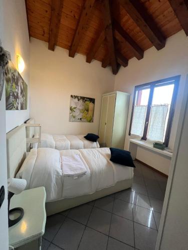 1 dormitorio con 2 camas en una habitación con techos de madera en La Divina en SantʼAgata Bolognese