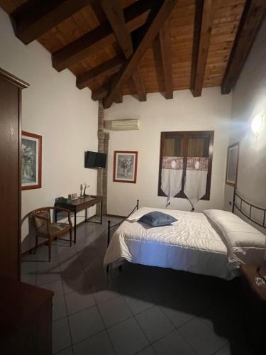 een slaapkamer met een bed en een bureau in een kamer bij La Divina in SantʼAgata Bolognese