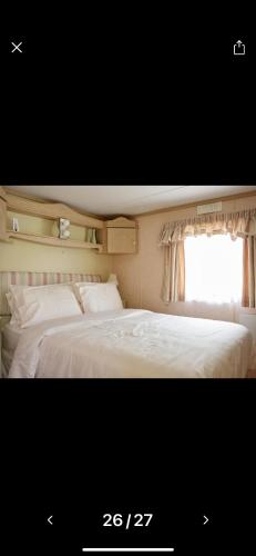 um quarto com 2 camas brancas e uma janela em Rogers Retreat em Scratby
