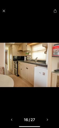 uma cozinha com um fogão e um lavatório em Rogers Retreat em Scratby
