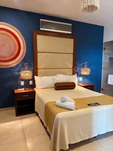 a bedroom with a large bed with a blue wall at Suites Valentina in Puerto Morelos