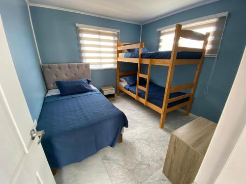 a bedroom with two bunk beds and a ladder at Casas el Quisco norte in El Quisco