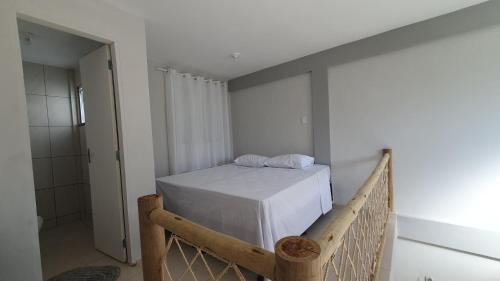 カウカイアにあるVidaBela Lofts Cumbuco CEの小さなベッドルーム(白いシーツ付きのベッド1台付)