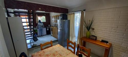 uma pequena cozinha com uma mesa e um frigorífico em Casa El Tabo em El Tabo