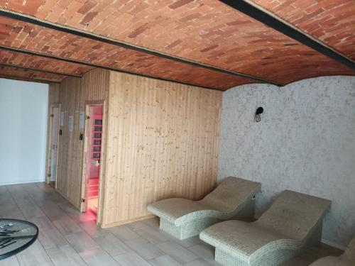 a room with two chairs and a wooden wall at Noclegi i sauna w starym domu in Pławnica
