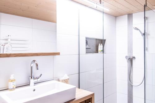 W łazience znajduje się umywalka i prysznic. w obiekcie Bauernhof Hammerer w mieście Egg