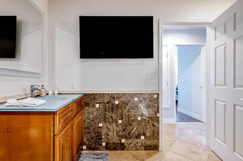 a bathroom with a sink and a television on the wall at Desert Cottage in Fountain Hills