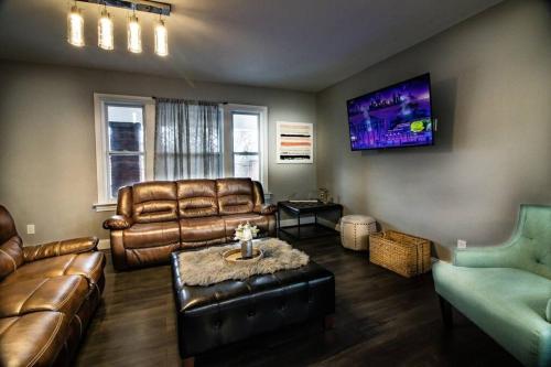 a living room with leather furniture and a flat screen tv at Quaint 3BR, 1 Bath near the falls in Niagara Falls