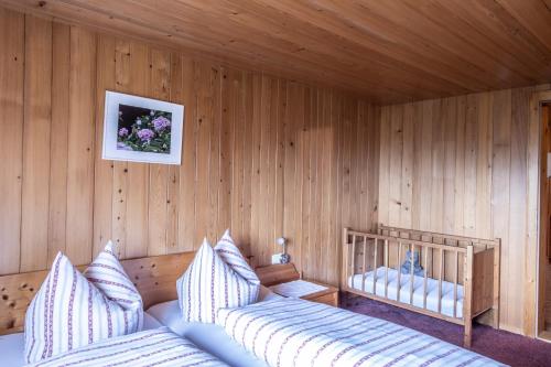 um quarto com 2 camas num quarto de madeira em Bauernhof Hammerer em Egg