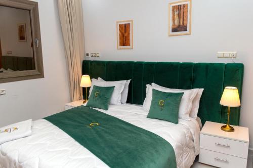 a bedroom with a green and white bed with pillows at Hotel Golden Sunset Dakhla in Dakhla