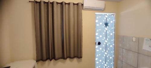 a bathroom with a shower curtain in a room at Pousada do Joca Bonito/MS in Bonito