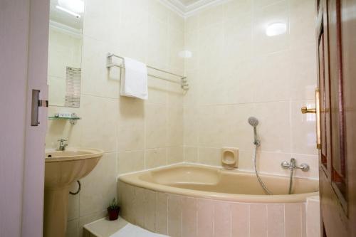 a bathroom with a bath tub and a sink at Hillview Holiday Condo in Harare