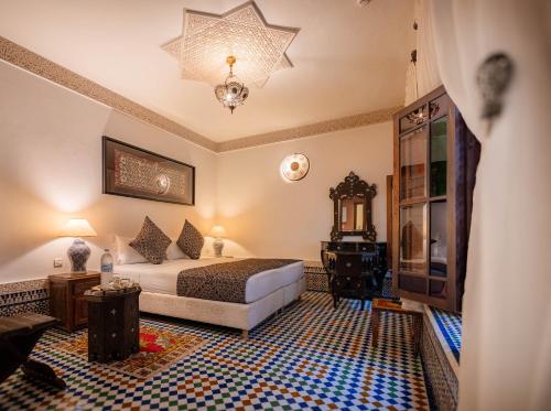 a hotel room with a bed and a chandelier at Riad Mazar in Fez