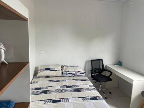 a bedroom with a bed and a desk and a chair at Apto Serras Gerais in Dianópolis
