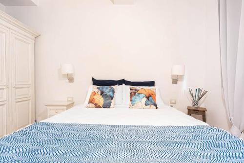 Un dormitorio blanco con una cama azul y blanca con almohadas en Poggio Imperiale House(Porta Romana), en Florencia