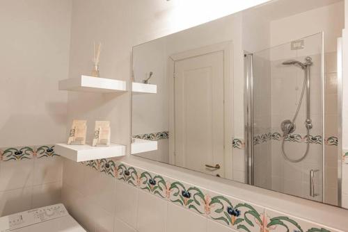 un baño con ducha y espejo en Poggio Imperiale House(Porta Romana), en Florencia