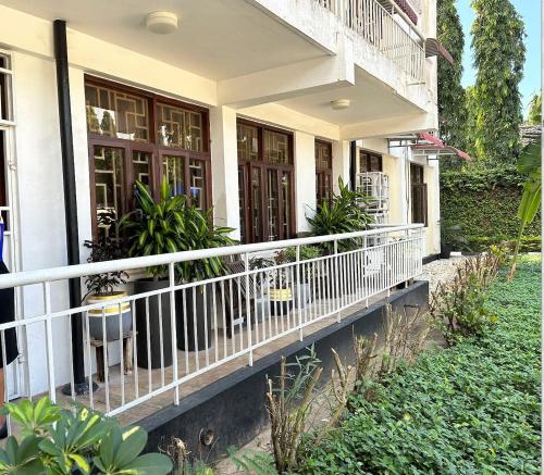 una casa con un balcón con plantas. en the only lovely apartment, en Dar es Salaam