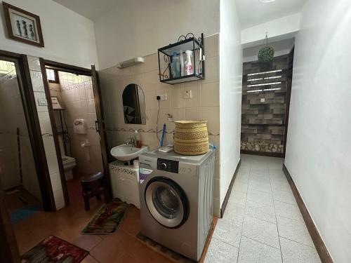 a bathroom with a washing machine and a sink at the only lovely apartment in Dar es Salaam