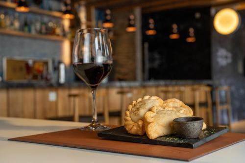 a glass of wine sitting next to a plate of bread at Hampton By Hilton Bariloche in San Carlos de Bariloche