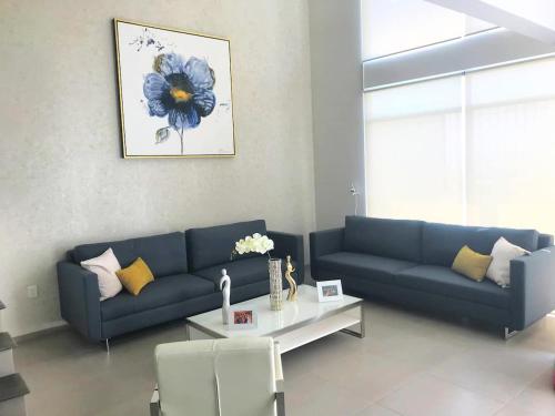 a living room with a blue couch and a table at Luxury house with all the amenities Gym Seg Aa cal Pool Tv Wifi in Querétaro