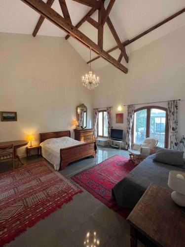 - une grande chambre avec 2 lits et un lustre dans l'établissement The hat factory, à Espéraza