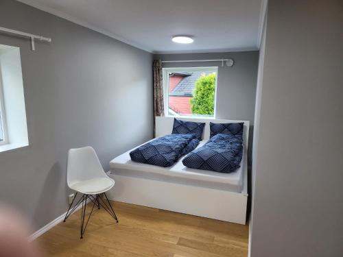 um pequeno quarto com uma cama e uma janela em Nesttunveien appartments em Bergen