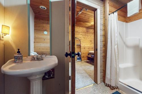 uma casa de banho com um lavatório e uma banheira em Evergreen Cottage em South Lake Tahoe