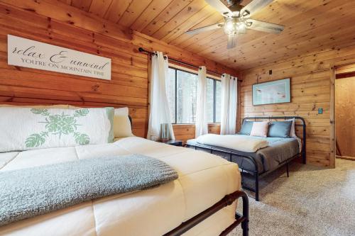um quarto com 2 camas num chalé de madeira em Evergreen Cottage em South Lake Tahoe