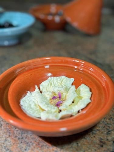 an orange bowl with a flower in it on a counter at Riad Mazar in Fès