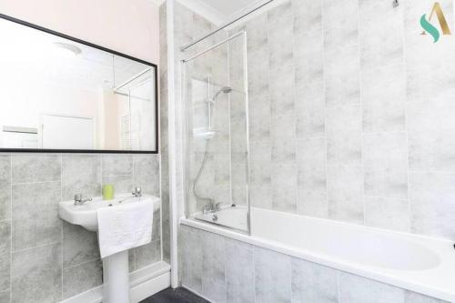 a bathroom with a tub and a sink and a shower at Holt house in Hartlepool