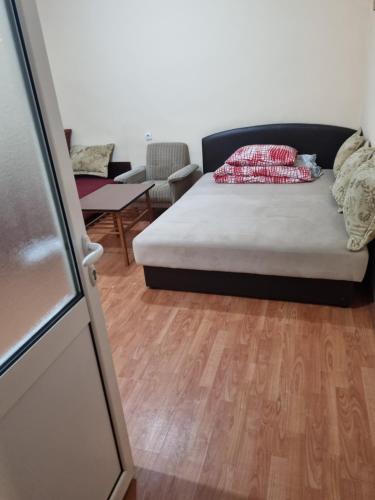 a bedroom with a bed and a wooden floor at Apartman Ristovic preko puta poste poste 01 in Mataruška Banja