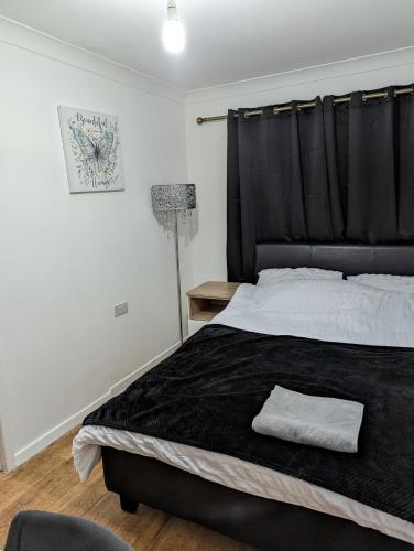 um quarto com uma cama grande e uma cabeceira preta em Luxury flat em Nevendon