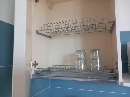 un bagno con mensola e 2 bicchieri di FARO vicino al mare BluDiPietraLigure a Pietra Ligure
